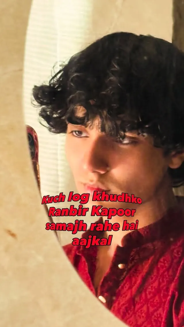 Aayan in a red shirt, reflected in a mirror